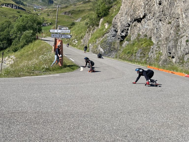 Des skaters dans un virage de la route qui descend de la station