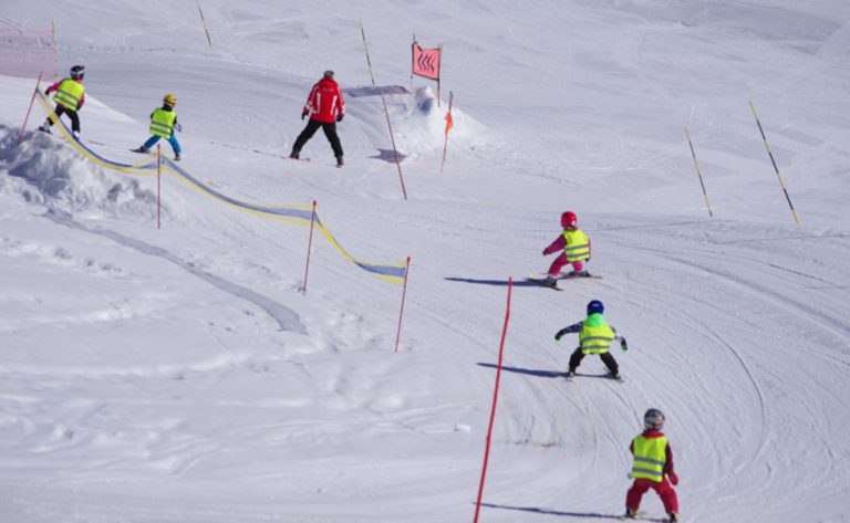 Des jeunes skieurs et le moniteur de ski