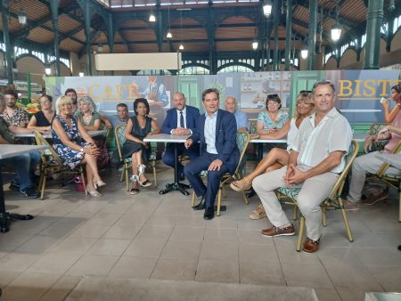 des personnes à des tables de bistro dans une  halle gourmande