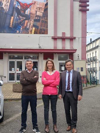 3 personnes devant un cinéma avec Spiderman au-dessus d'eux