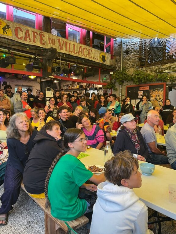 foule de personnes attablées sous un toit couleur jaune
